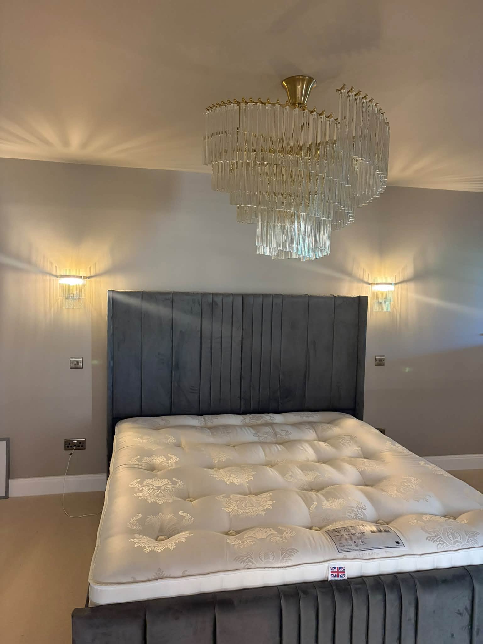 Closer view of the bedroom chandelier and wall lights